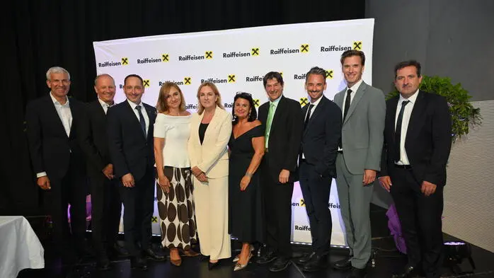 Einige Männer und Frauen lächeln in die Kamera und posieren für ein Foto.