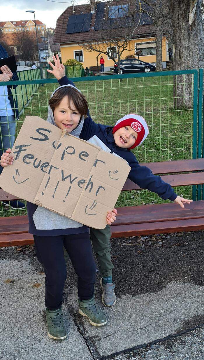 Dominik (rechts) jubelt der Feuerwehr mit seinem Bruder zu