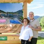 Zwei Menschen stehen neben einer Holztafel mit der Aufschrift „Beach Club“