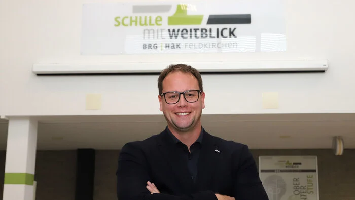 Ein Mann steht vor einer Schultafel