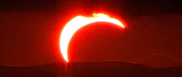 Eine dunkelrote Sichel bei der Sonnenfinsternis 2026 
