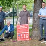 Vier Männer und zwei Hunde „posieren“ für ein Foto in einer Hundefreilaufzone.