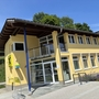 Ein gelbes Gebüde von außen. Mit der Aufschrift „Raiffeisenbank“