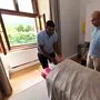 Zwei Masseure in einem Behandlungsraum. Eine Dame bekommt gerade eine Kopfmassage. 
