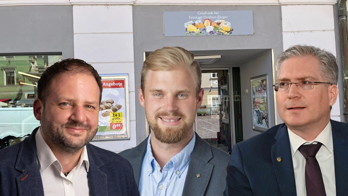 Ein Geschäft von außen. Davor die drei Köpfe der Politiker 