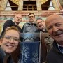 Fünf Menschen lachen in die Kamera hinter ihnen eine Orgel 