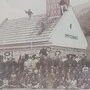 Ein Schwarzweißfoto einer Feuerwehr. Viele Leute sitzen als Gruppe zusammen 