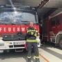 Ein Mann steht mit verschränkten Armen vor einem Feuerwehrauto 