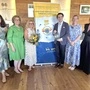 Fünf Frauen und ein Mann posieren für ein Foto und lächeln in die Kamera.