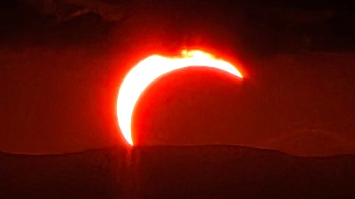 Eine dunkelrote Sichel bei der Sonnenfinsternis 2026 
