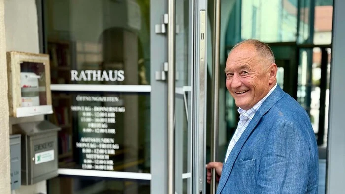 Ein Mann steht vor einer Glastür beim Rathaus