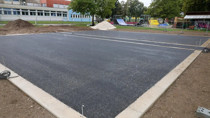 Ein Tennisplatz aus Asphalt auf einer Wiese.