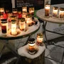 Zwei Stehtische vor einem Lokal mit mehreren Kerzen  | Vor der Rockfiliale wurden, seit dem Todestag von Sobian, mehrere Kerzen angezündet 