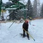 Ein Mann mit Schneeschaufel vor einem eingeschneiten Lift 