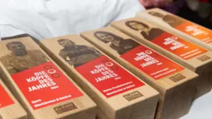 Fünf Trophäen aus Holz mit Porträts der Sieger und Siegerinnen. Darauf steht „Die Köpfe des Jahres“. | Langsam geht die Wahl der Köpfe des Jahres in die heiße Phase (Symbolbild)