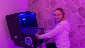 Leiterin Silvia Liker vom neuen „VitaFontes“ sitzt auf einem Stuhl. Ihre Hände stecken in einem „Alpha Cooling“-Gerät, das zur Kälteanwendung dient | Leiterin Silvia Liker zeigt eine Kälteanwendung mit „Alpha Cooling“ im neuen „VitaFontes“ 