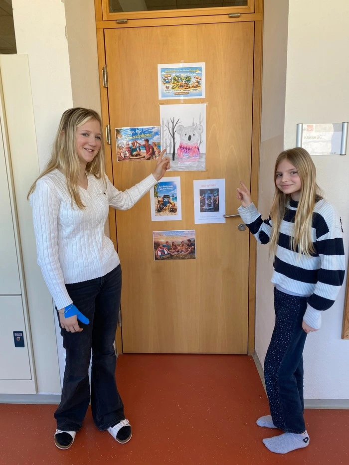 Amelie Grill und Cheyenne Sollhart (von links) zeigen auf die Bilder, die ihre Handys „im Urlaub“ zeigen