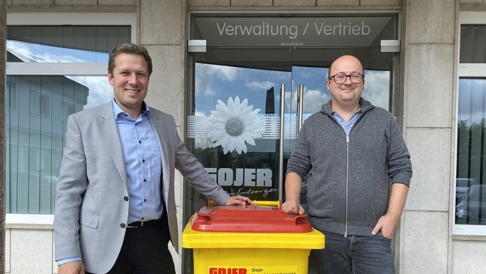 Die Gojer-Geschäftsführer Michael Bergmann und Ludwig Gojer vor dem Vertriebsgebäude mit einer gelben Gojer-Mülltonne | Die neue Doppelspitze: Michael Bergmann und Ludwig Gojer (von links)