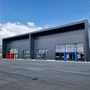 Das Bild zeigt die mietbare Gewerbehalle von außen. Sie ist ganz in dunkelgrau gehalten
