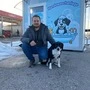 Geschäftsführer Patrick Saloschnik hockt mit seiner Hündin Luna vor der Hundewaschanlage, die in einem Container untergebracht ist | Geschäftsführer Patrick Saloschnik mit seiner Hündin Luna vor der Hundewaschanlage