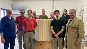 Johann (links) und Josef (rechts) Erschen stehen mit den Mitarbeitern Erhard Oschina, Celine Kelih, Ewald Stanz, Benjamin Wastl, Sigi Erschen (auch ein Bruder), Thomas Telsnig und Klemens Reinfried (von links) in der Werkstatt um ein Möbelstück