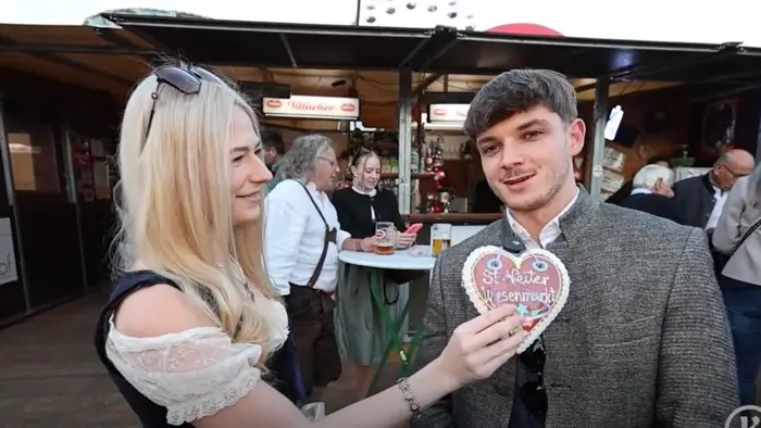 Frau interviewt mit Lebkuchenherz-Mikro