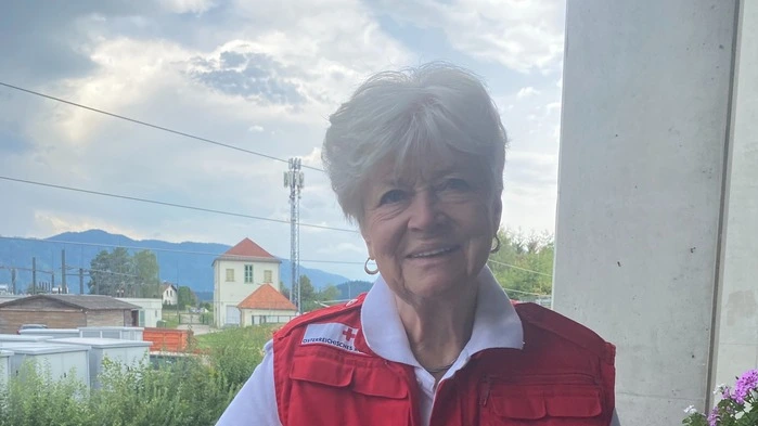 Renate Huber steht in der Rotkreuz-Jacke auf dem Balkon ihrer Wohnung