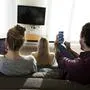 Friends sitting on couch in livingroom, using digital devices model released Symbolfoto property released PUBLICATIONxINxGERxSUIxAUTxHUNxONLY VABF02182  