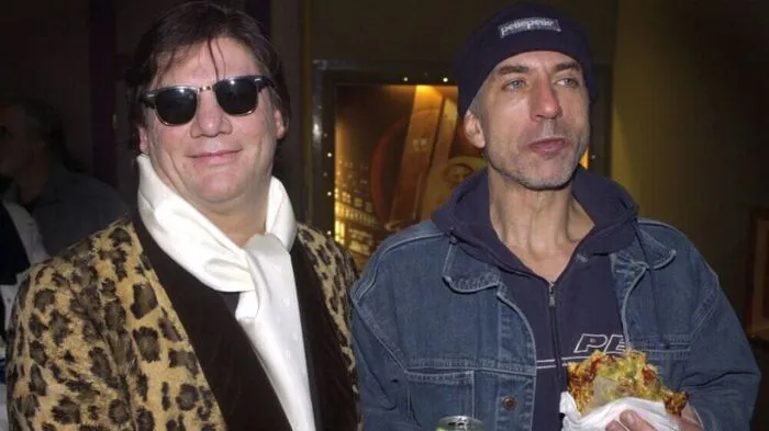 Der Regisseur Claude-Oliver Rudolph (l) und sein Nebendarsteller Ralf Richter stehen am Mittwoch (08.01.2003) zu Beginn der Welturaufführung ihres neuen Films "Dirty Sky" nebeneinander in Rudolphs Geburtsstadt Bochum. Richter war erst wenige Minuten vor dem Filmbeginn gekommen und hatte sich etwas zu Essen und zu Trinken mitgebracht. Die Hauptdarsteller Cosma Shiva Hagen und Nikolai Kinski waren nicht anwesend. Fotograf: Bernd Thissen dpa/lnw
