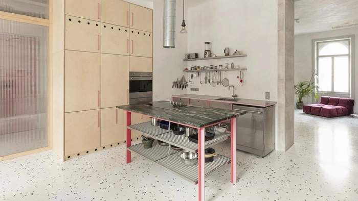Die Bresche von der Küche ins Wohnzimmer, sichtbare Rohre und Terrazzo mit Rosaton