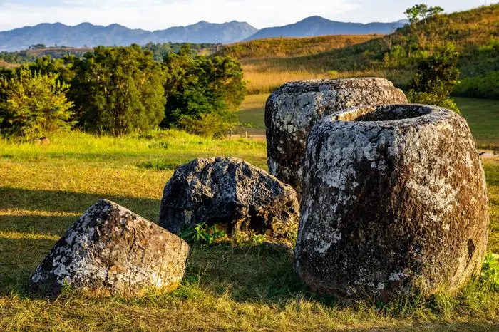 The Plain of Jars, a megalithic archaeological landscape in Laos. Xieng Khouang at golden hour. Model Released Property Released xkwx ancient antique archaeological asia attraction cultural destination field landmark landscape laos meadow megalithic monument old outdoors plain of jars prehistoric remains sightseeing stone tourism travel trip unesco world heritage site valley xieng khouang