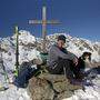 Das Gipfelkreuz auf dem Naßfeldriegel (2238 m) mit dem Hochtristen (2536 m) im Hintergrund