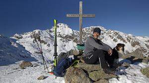 Das Gipfelkreuz auf dem Naßfeldriegel (2238 m) mit dem Hochtristen (2536 m) im Hintergrund