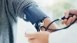 Doctor, blood pressure and patient appointment in clinic, professional consultation and monitor or healthcare. People, wellness and medical help or hypertension, heart rate and equipment in hospital.