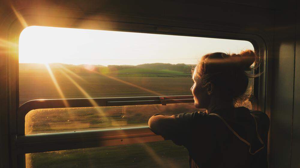 Woman Train window sunset | Diese Nachtzugverbindungen führen über besonders schöne Strecken