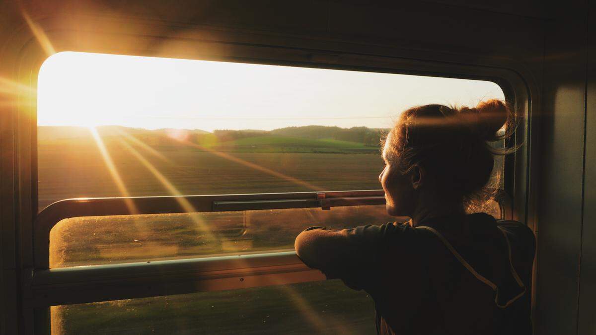 Woman Train window sunset | Diese Nachtzugverbindungen führen über besonders schöne Strecken