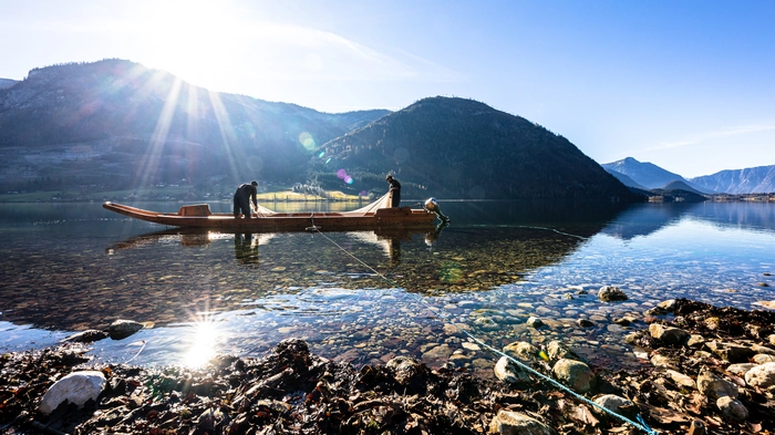 Grundlsee mit Bergpanorama im Hintergrund und einem Fischerboot