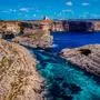 A stunning aerial view of the Blue Lagoon in Comino, Malta with clear turquoise waters and rocky cliffs under a bright blue sky. 25802677 RECORD DATE NOT STATED 