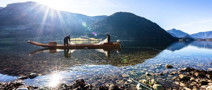 Grundlsee mit Bergpanorama im Hintergrund und einem Fischerboot