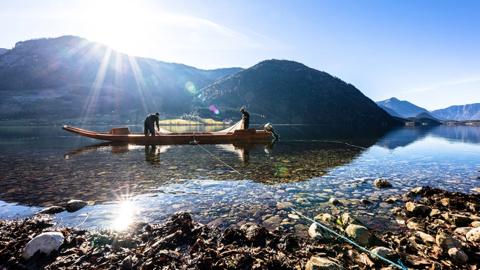 Grundlsee mit Bergpanorama im Hintergrund und einem Fischerboot