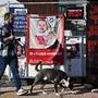 A man walks a dog past a poster of a 10 month old baby Kfir Bibas held captive by Hamas in Gaza at Hostage Square outside the Tel Aviv Museum in Tel Aviv, on Saturday, December 16, 2023. Israeli forces opened fire, killing three hostages mistaken for Hamas. PUBLICATIONxINxGERxSUIxAUTxHUNxONLY JER2023121719 DEBBIExHILL