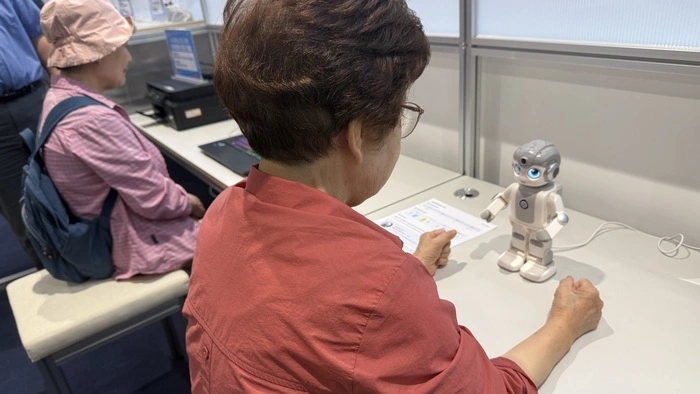 Seniorinnen agieren mit einem menschlichen Roboter im KI-Lernzentrum in Seoul