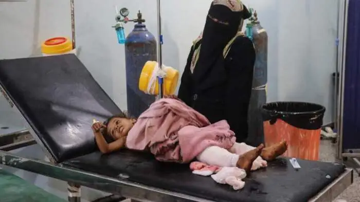 A woman stands beside an injured child receiving treatment at a hospital following a reported Houthi drone strike in the Mash'a area of Hays, south of Hodeidah, on August 18, 2026. Yemen, which has been embroiled in more than a decade of civil conflict, last month became the latest country to be dragged into the Middle East war as the Iran-backed Houthis upended the 2022 truce with the Saudi-backed government, ramping up attacks on areas it holds. (Photo by Khaled ZIAD / AFP)