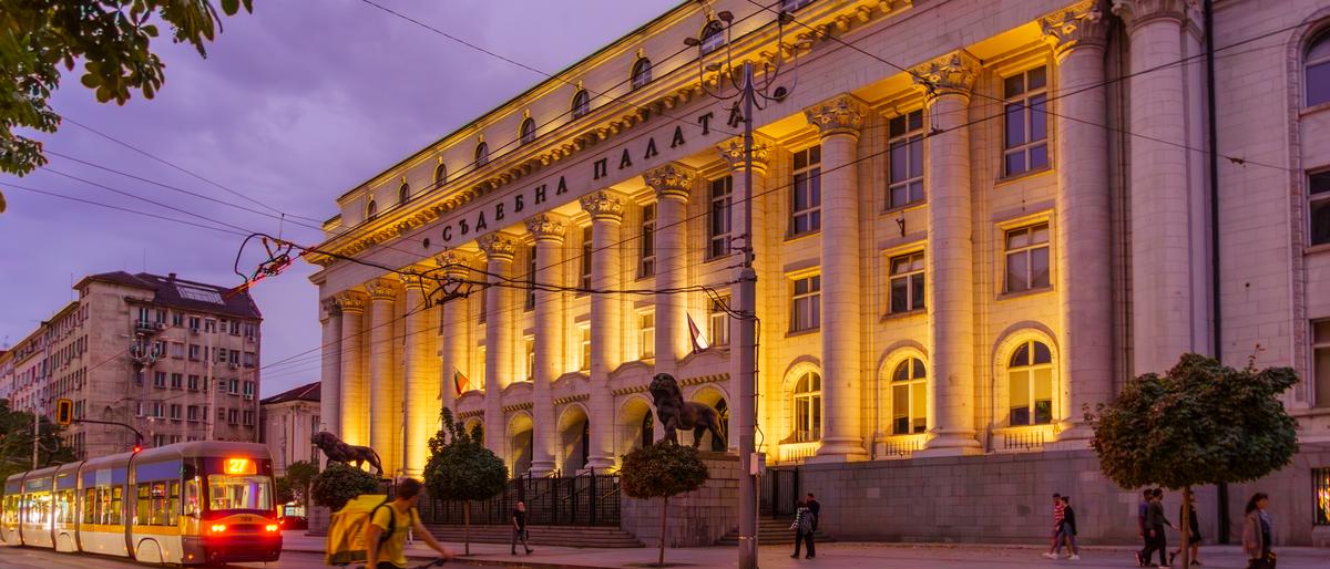 Sofia, Bulgaria - September 14, 2023: Evening view of the City Court building, with a tram, locals, and visitors, in Sofia, Bulgaria   xkwx architecture balkan bicycle building bulgaria bulgarian capital city cityscape classical column court court house courthouse culture cyclist europe european evening facade famous historic historical history house justice landmark legal legislation lion monument old palace road scene sculpture sofia statue street structure tourism town train tram travel urban