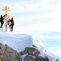  Die im Tal restaurierten Strahlen des Gipfelkreuzes der Zugspitze werden von Mitarbeitern wieder zum Gipfelkreuz gebracht. 