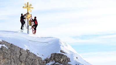  Die im Tal restaurierten Strahlen des Gipfelkreuzes der Zugspitze werden von Mitarbeitern wieder zum Gipfelkreuz gebracht. 