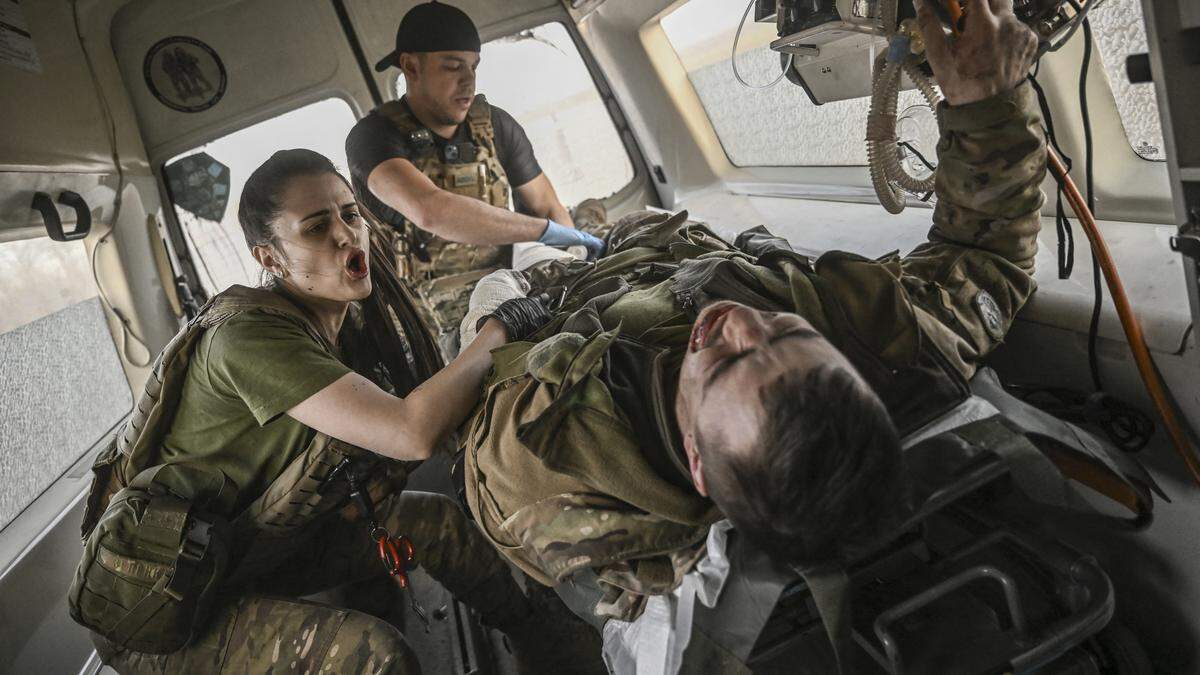 Ukrainische Sanitäter evakuieren einen verwundeten Soldaten