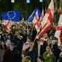 Protesters wave flags during a pro-Europe rally ahead of the parliamentary elections, which are seen as a crucial test for the country's democracy and its bid for EU membership, in Tbilisi on October 20, 2024. Tens of thousands of demonstrators, waving EU and Georgian flags and holding banners that read "Georgia chooses the European Union" gathered at Tbilisi's central Freedom Square after marching toward the venue from five different locations. (Photo by Vano SHLAMOV / AFP)