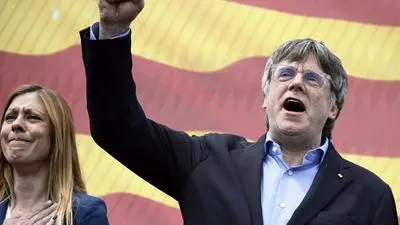 (FILES) Catalan separatist leader and candidate of Junts per Catalunya - JxCat political party, Carles Puigdemont (R) raises his fist during a campaign rally in the French southeastern town of Argeles-sur-Mer on May 4, 2024 ahead of the regional election in the Spanish northeastern region of Catalonia. Puigdemont, president!" chanted an excited crowd waiting to enter a campaign rally in Argeles-sur-Mer, a French seaside town near the Spanish border in an area Catalan separatists refer to as "Northern Catalonia". It is here that Carles Puigdemont, the self-exiled Catalan separatist leader, has set up his campaign headquarters ahead of elections on May 12, 2024, in the northeastern Spanish region of Catalonia, which lies just 30 kilometres (18 miles) across the border. (Photo by Josep LAGO / AFP)