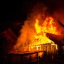 Ein lichterloh brennendes Haus vor dunklem Nachthimmel. Die Flammen schießen meterhoch in die Höhe.  | Das Haus, in dem drei Menschen wohnten, brannte bis auf die Grundmauern nieder. Erst als sich herausstellte, dass einer der Bewohner nicht in den Flammen ums Leben kam, wurde die Unfalltheorie infrage gestellt. (Symbolfoto)